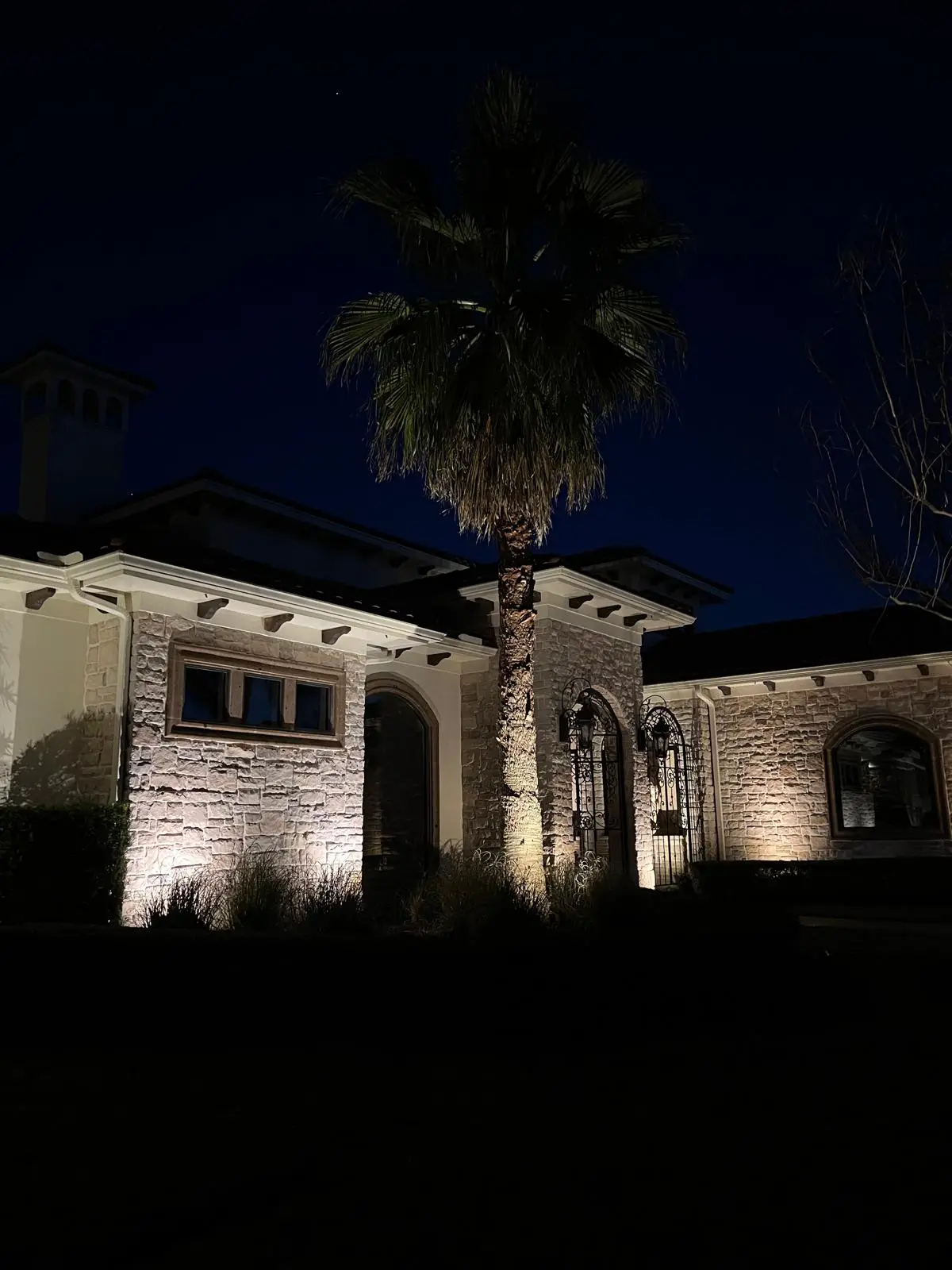 Elegant landscape and outdoor lighting design highlighting home's exterior and gardens